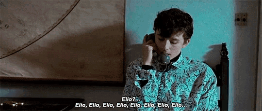 a young man is talking on a telephone in a room .