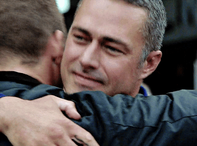 two men are hugging each other and one has a tattoo on his arm