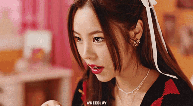 a close up of a woman 's face with the word wheeluv on the bottom right