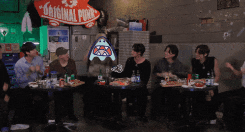 a group of people sitting around a table with a sign that says original pony