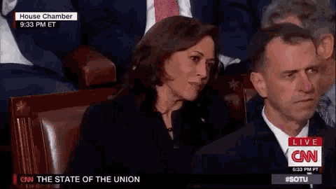a man and a woman are sitting in a row in a cnn live broadcast .