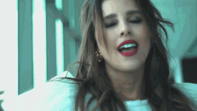 a close up of a woman 's face with her eyes closed and red lips .
