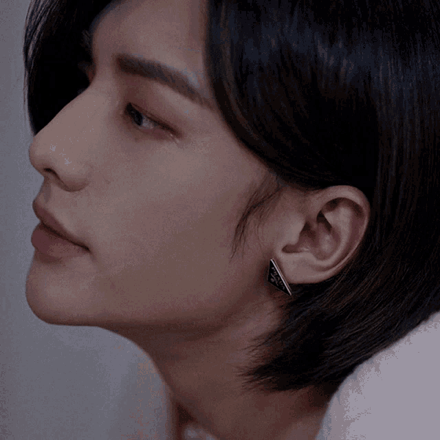 a close up of a person 's face with a pair of earrings