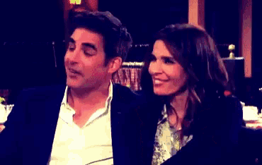 a man and a woman are sitting next to each other in a dark room .