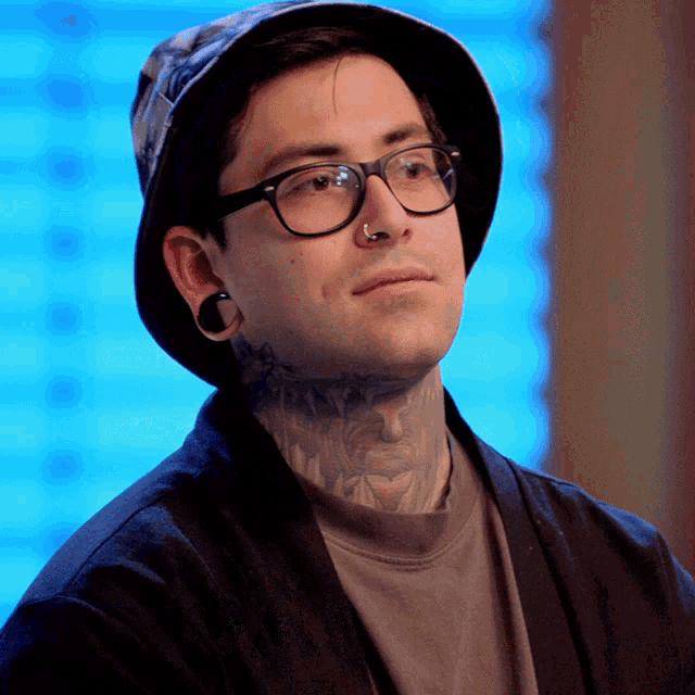 a man with a tattoo on his neck wearing a hat and glasses