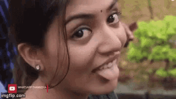 a woman is sticking her tongue out while smiling .