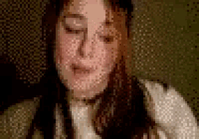a close up of a woman 's face with her eyes closed and a blurred background .