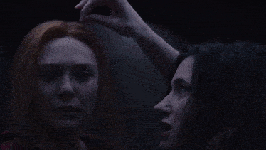 two women are looking at each other with their eyes closed