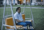 a man is sitting on a swing in a park with the words `` all alone lol '' .