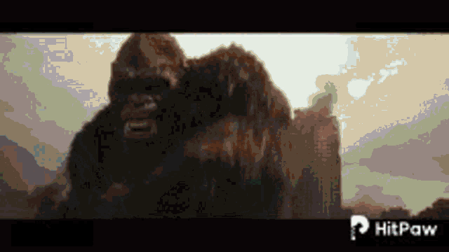 a giant gorilla is standing in front of a building in the mountains .