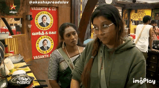 two women standing in front of a sign that says vasanth & co.