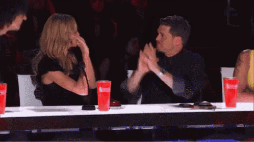 a man and a woman are sitting at a table with red cups that say coca cola on them