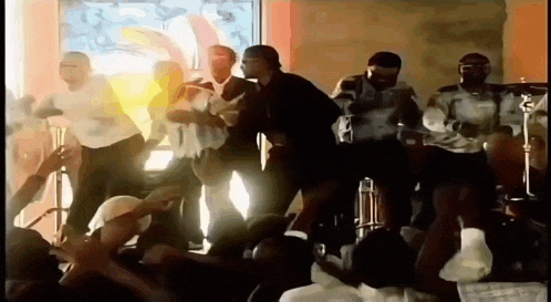 a group of men are dancing on stage in front of a crowd of people .
