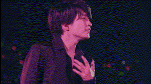 a man is holding another man 's neck in a dark room with red lights behind him .