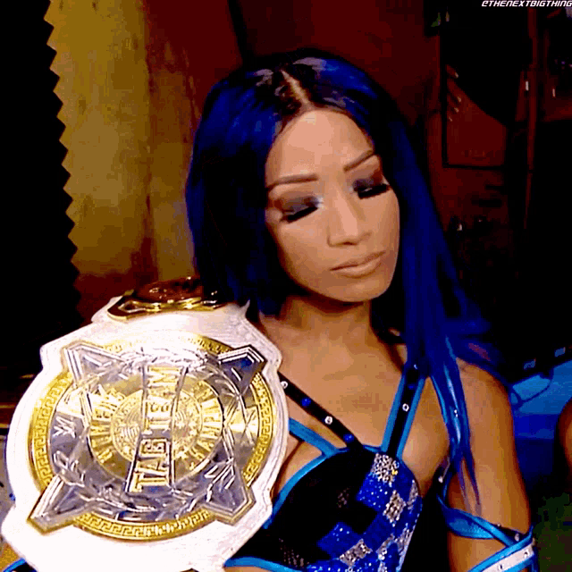 a woman with blue hair is holding a world heavyweight championship