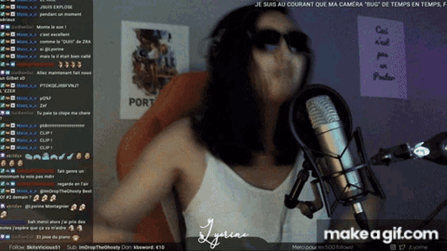 a woman wearing sunglasses stands in front of a microphone on a screen that says make a gif.com on it