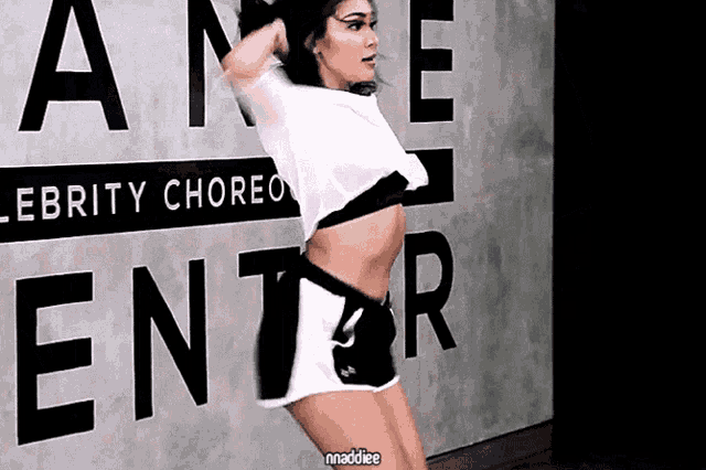 a woman is dancing in front of a sign that says " enter "