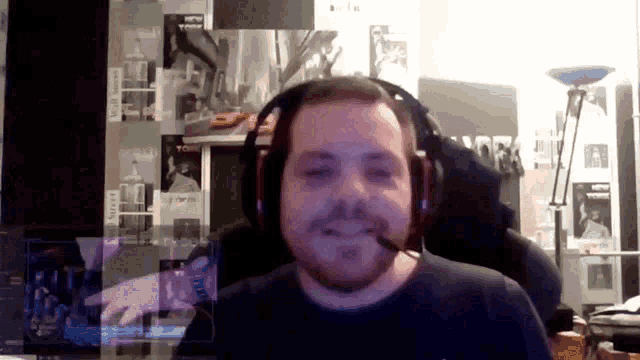 a man wearing headphones and a microphone looks at the camera with a wall behind him that says ' wall street '