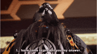 a man with a long beard says " have come to present you my answer "