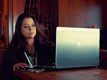 a woman sits at a table using a dell laptop computer