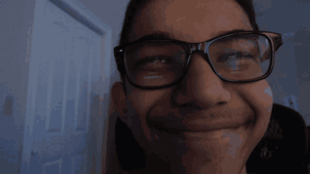 a close up of a person wearing glasses making a face