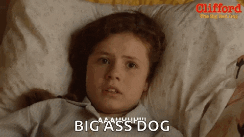 a little girl is laying on a bed with a pillow and the words big ass dog on the bottom