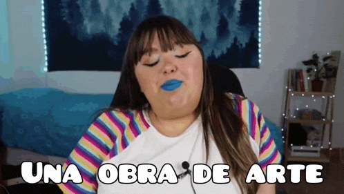 a woman with blue lipstick and the words una obra de arte on her chest