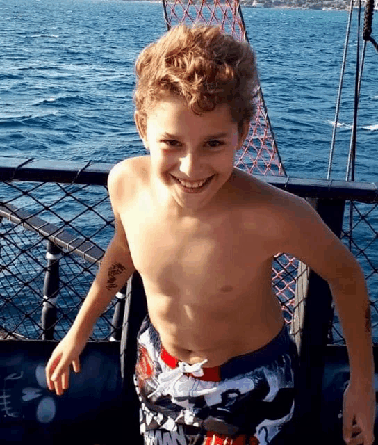 a shirtless boy with a tattoo on his arm that says barbie