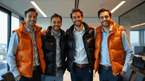 four men wearing orange vests are posing for a picture together