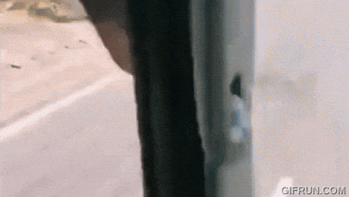 a person is standing in front of a window with a bullet hole in the door .