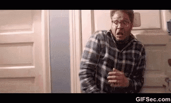 a man wearing glasses and a plaid shirt is standing in a doorway .