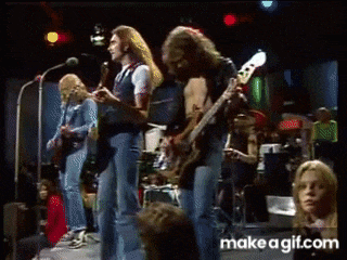 a group of people are playing instruments on a stage and the words make a gif.com are on the bottom of the screen .