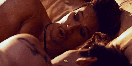 a man and a woman are laying in bed and the woman says no .