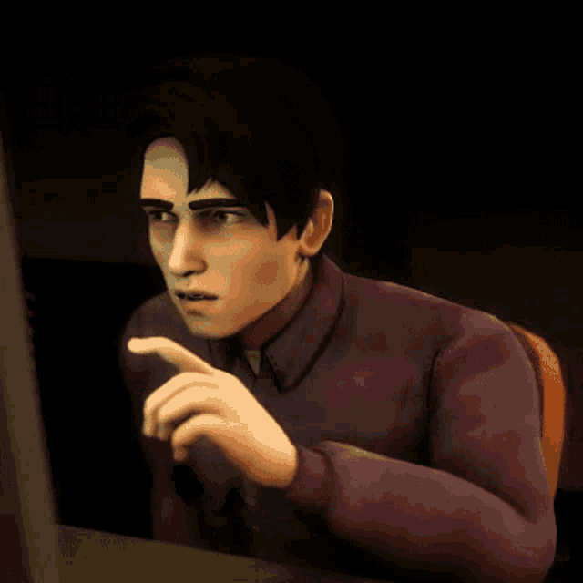 a man in a purple shirt is sitting in front of a computer monitor