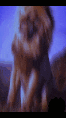 a blurry picture of a lion with a purple sky in the background