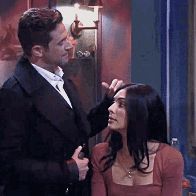a man and a woman are standing next to each other in a room .