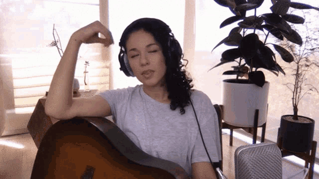 a woman wearing headphones is singing into a microphone