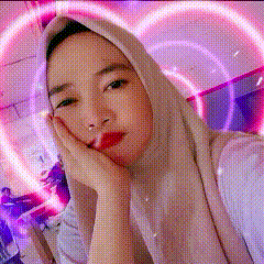 a woman wearing a hijab is taking a selfie in front of a heart shaped wall .
