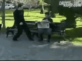 a man is walking past a man sitting on a park bench
