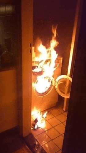 a washing machine is on fire in a bathroom