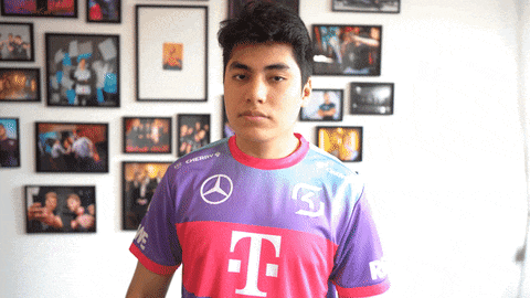 a young man wearing a t-mobile shirt stands in front of a wall of pictures