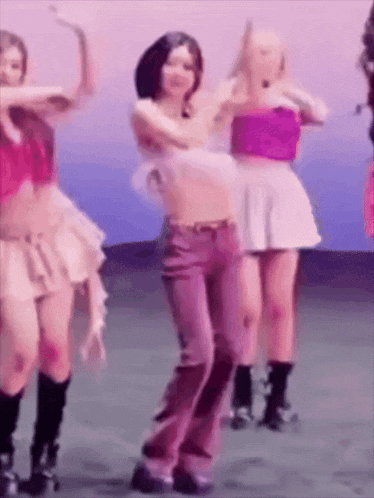 a group of women are dancing together on a stage in a room .