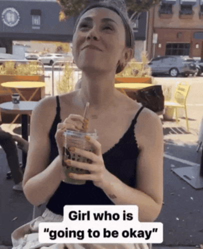 a woman holding a drink with the words girl who is " going to be okay " on the bottom