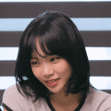 a close up of a woman 's face with short black hair
