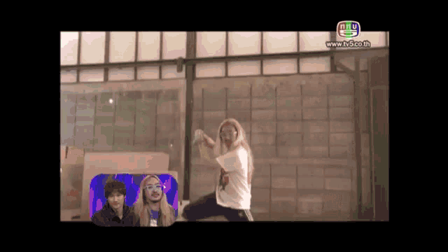 a woman is doing a karate move in front of a group of people on a television screen .