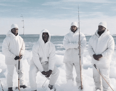 four men standing in the snow with fishing rods in their hands