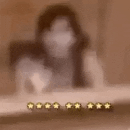a blurred image of a woman sitting at a table with a row of stars .