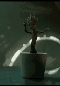 a small figurine of groot from guardians of the galaxy is dancing in a pot .