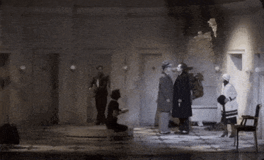 a group of people standing in a room with a door that has the number 10 on it