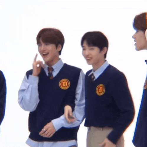 a group of young men wearing school uniforms and vests with the letter d on them .